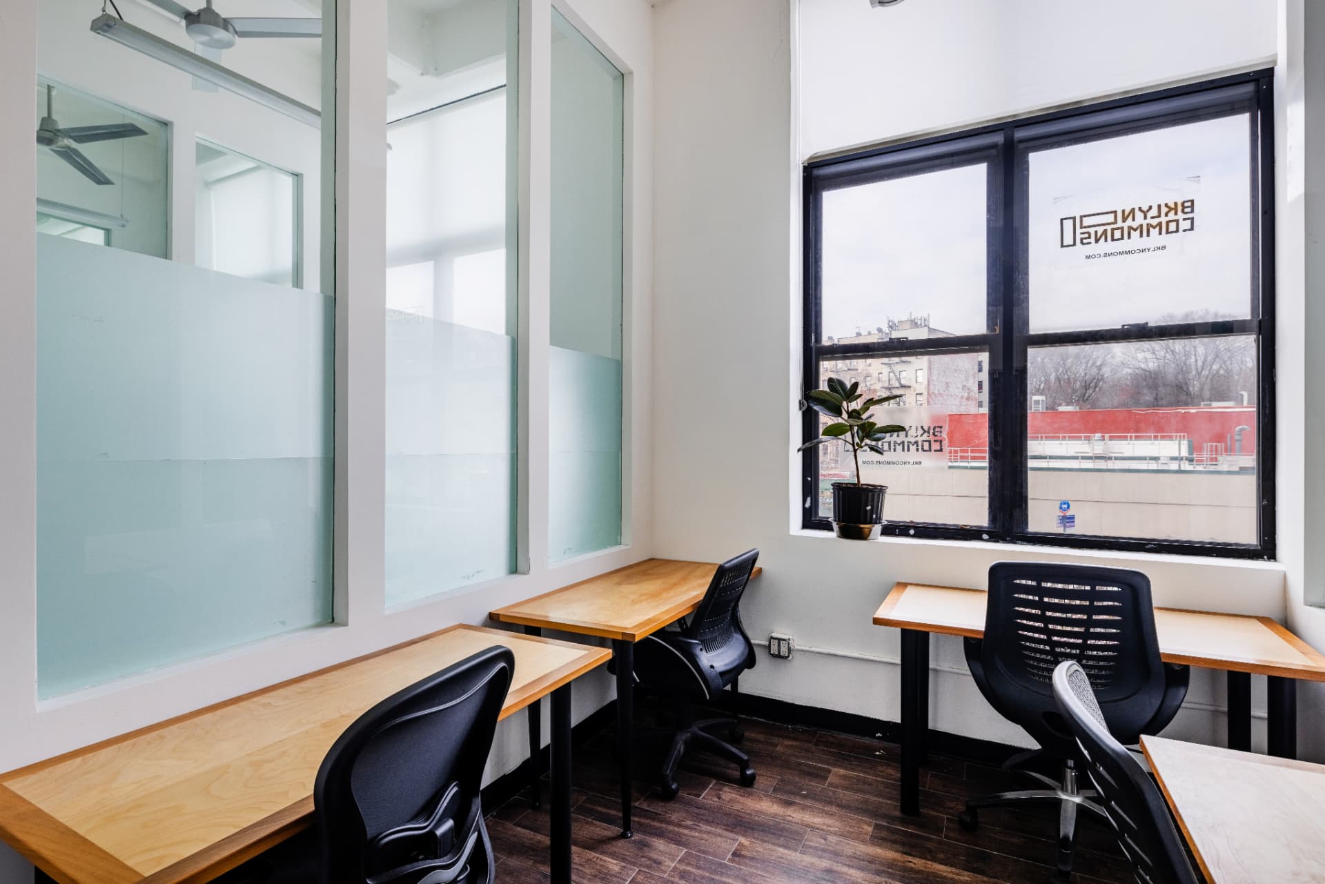 Bright four-person office with large windows overlooking Brooklyn at BKLYN Commons
