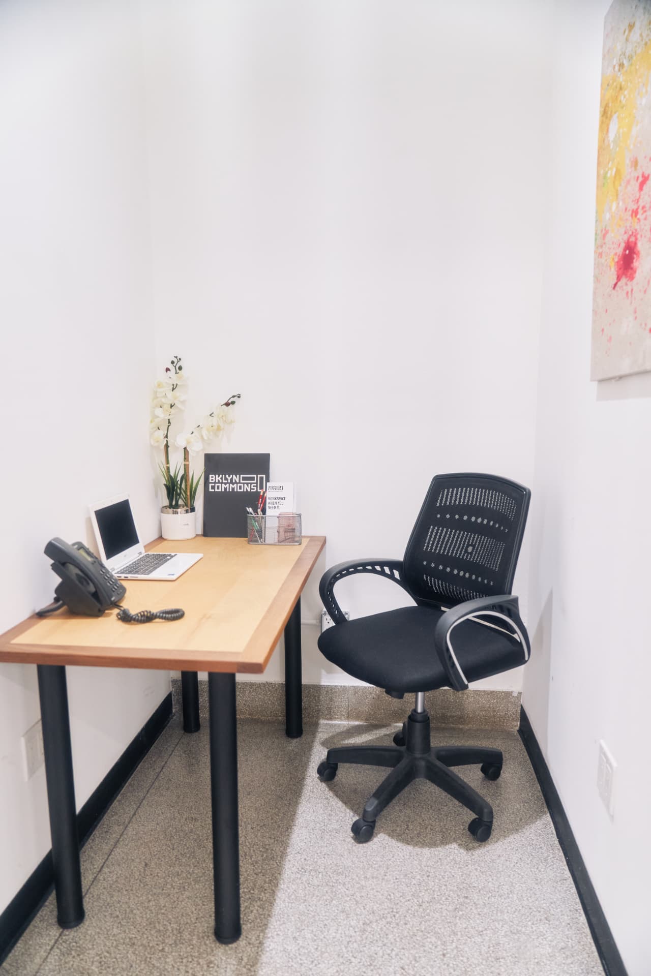 Single-person office desk with BKLYN Commons branding